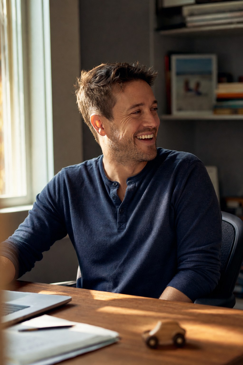 David, a 35-year-old founder, mid-laugh at his home-office desk